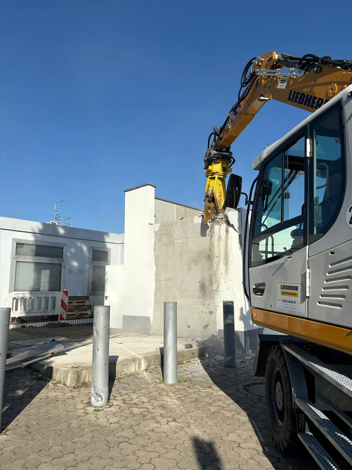 Abbruchbagger mit Sortiergreifer im Einsatz zwischen Gebäuden
